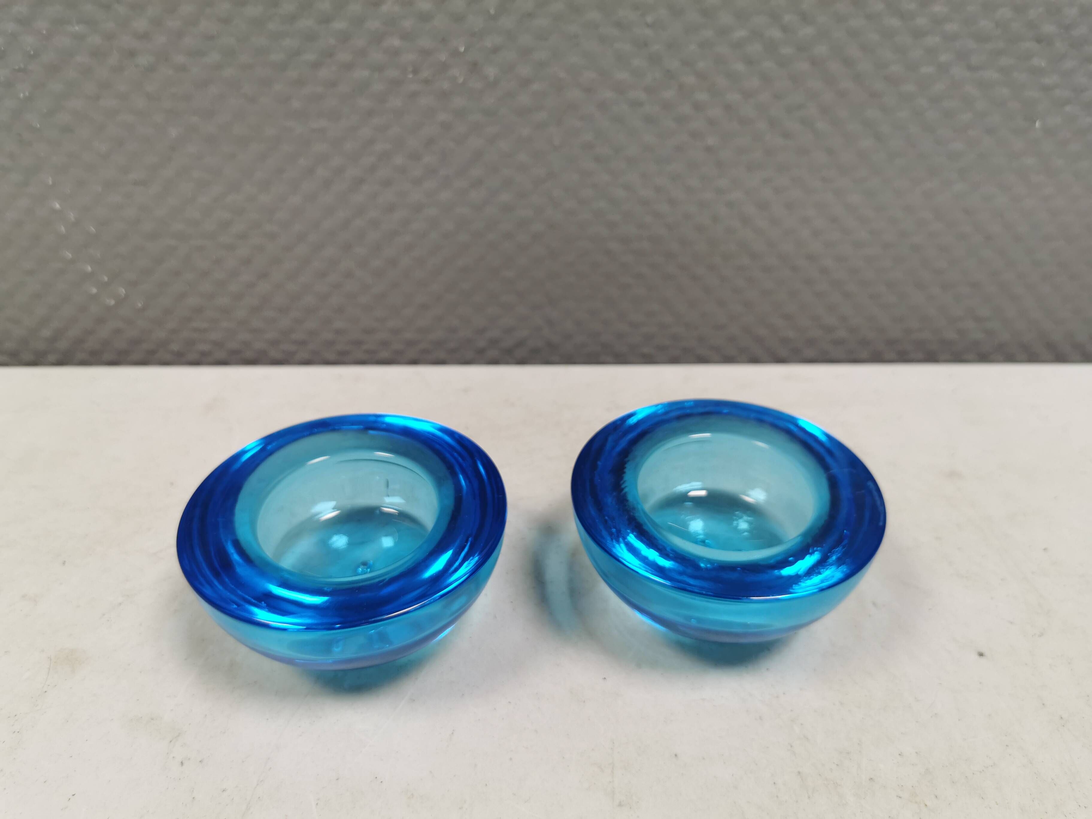 A set of iitalla candle holders in blue transparent glass.