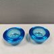 A set of iitalla candle holders in blue transparent glass.