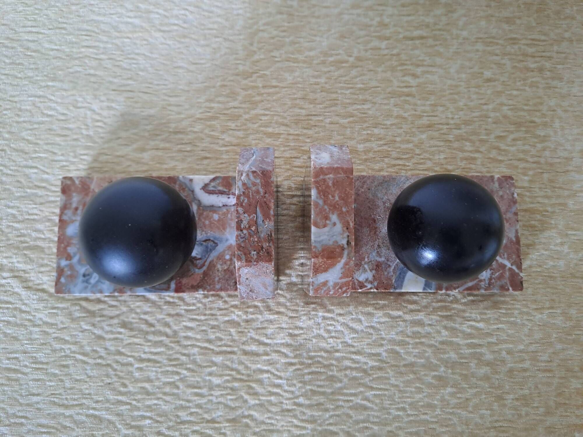 Pair of red marble bookends with black stone spheres – Art Style