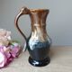 Vintage 1960s brown and blue flame-patterned stoneware wine jug carafe.