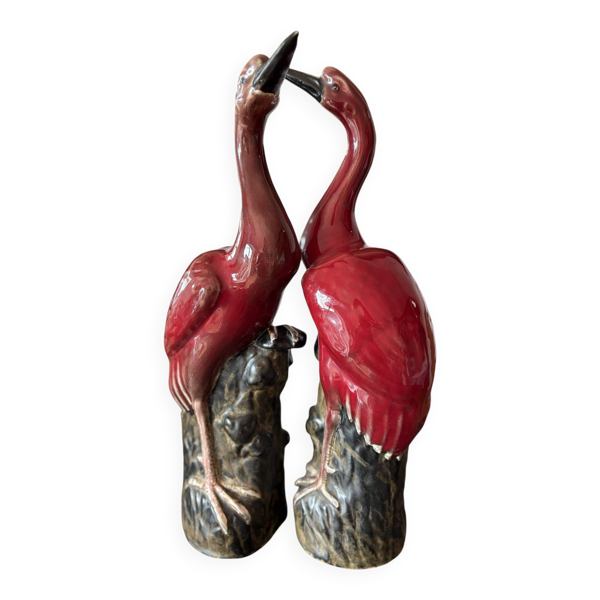 Paire de statuettes d’échassiers (grues) en céramique émaillée rouge
