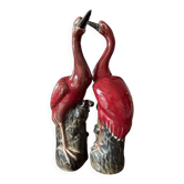 Paire de statuettes d’échassiers (grues) en céramique émaillée rouge