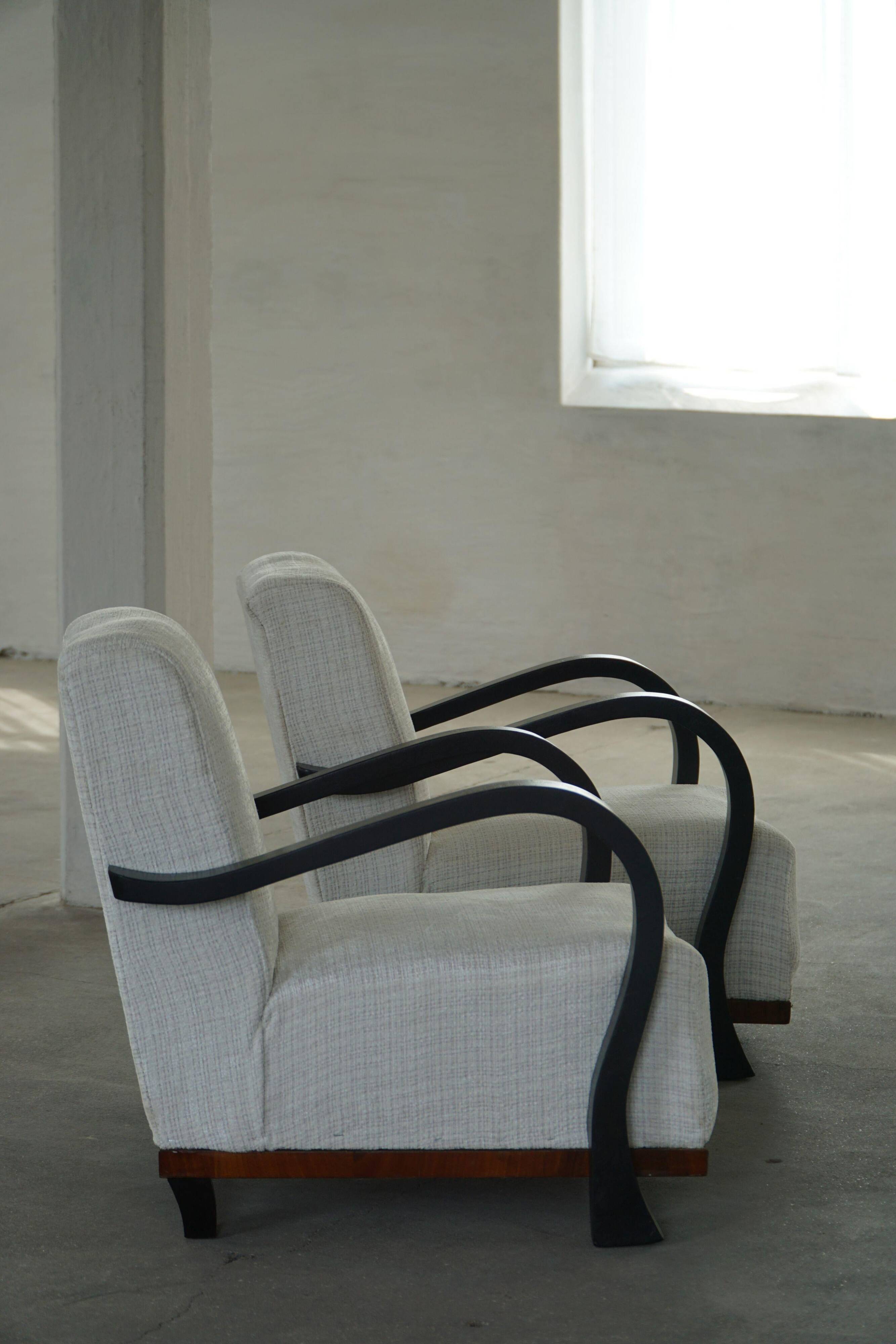 A pair of Swedish Art Deco lounge chairs with curved armrests, 1930s.