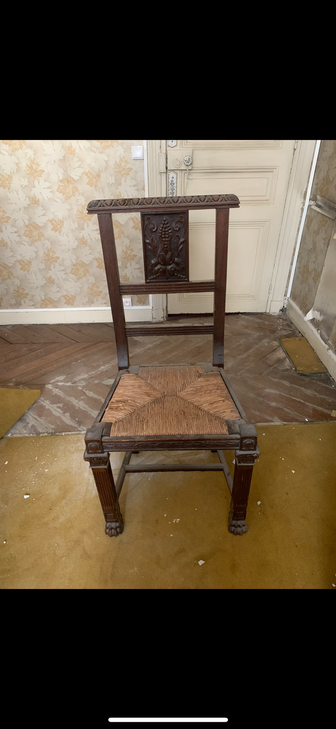 Antique carved wooden chairs with straw seats.
