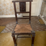 Antique carved wooden chairs with straw seats.