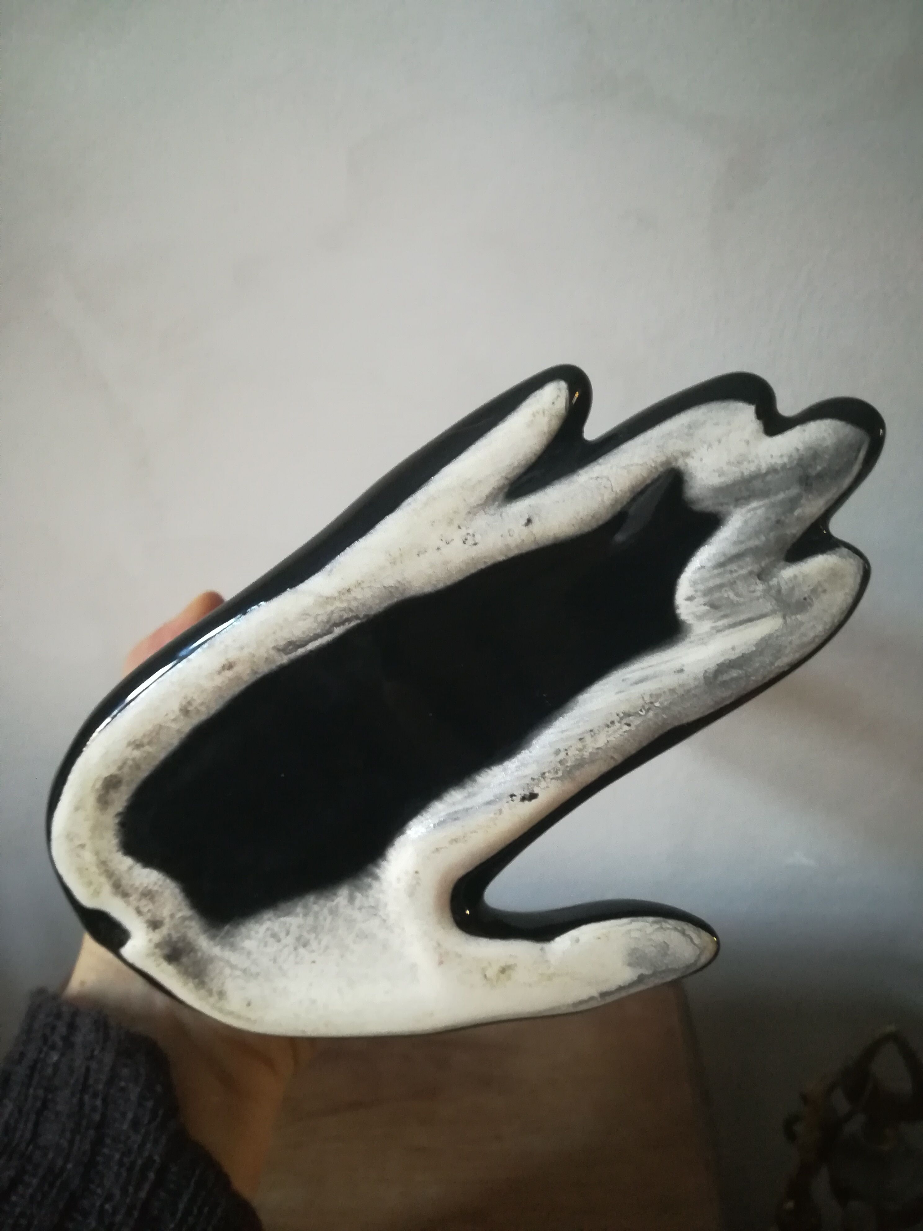Black earthenware vase gloved hand