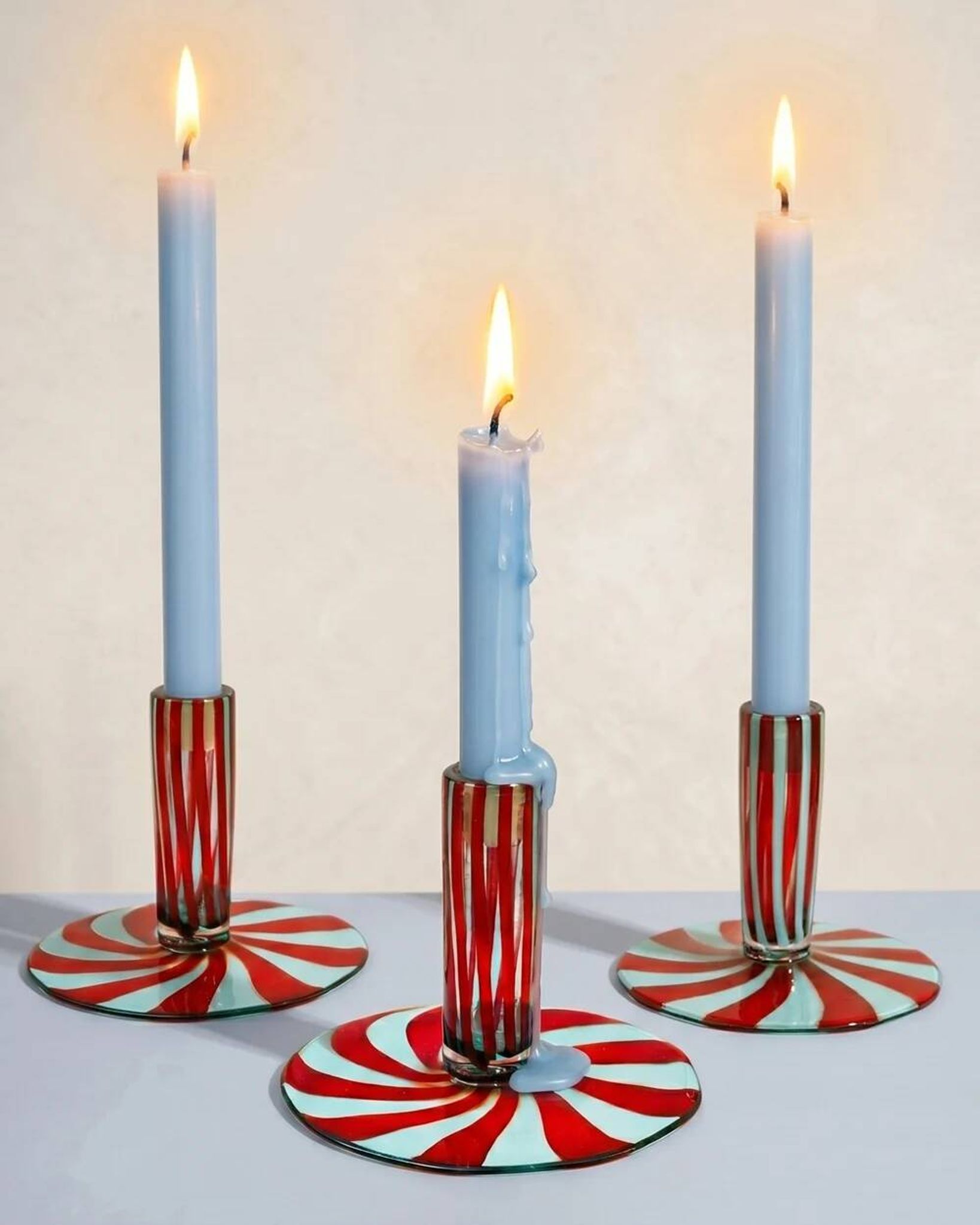 Murano glass candlestick with swirling red and blue ribbons.