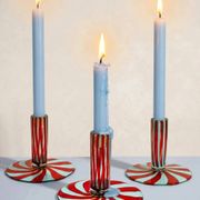Murano glass candlestick with swirling red and blue ribbons.