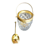 Glass and gold metal ice bucket with its gold metal spoon.