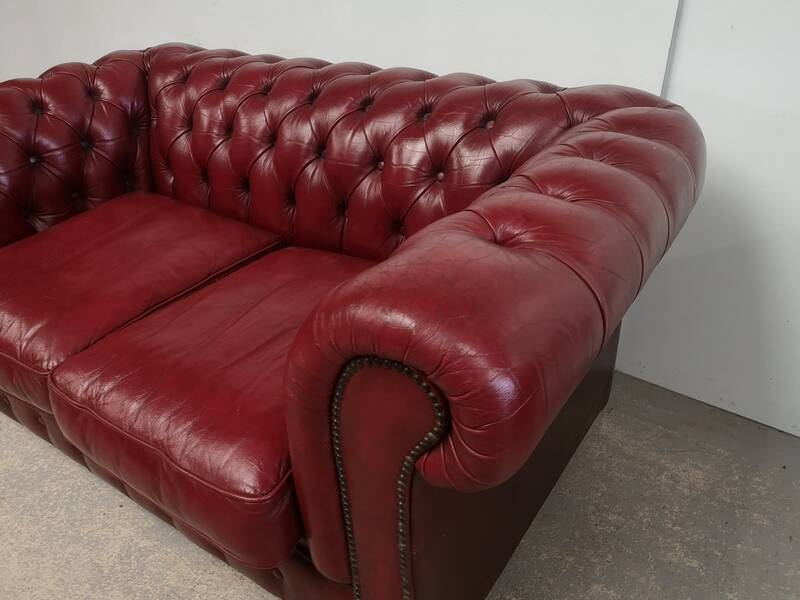 Red two-seater chesterfield sofa