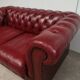 Red two-seater chesterfield sofa