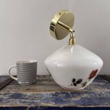 Golden tilting wall light with flowered globe