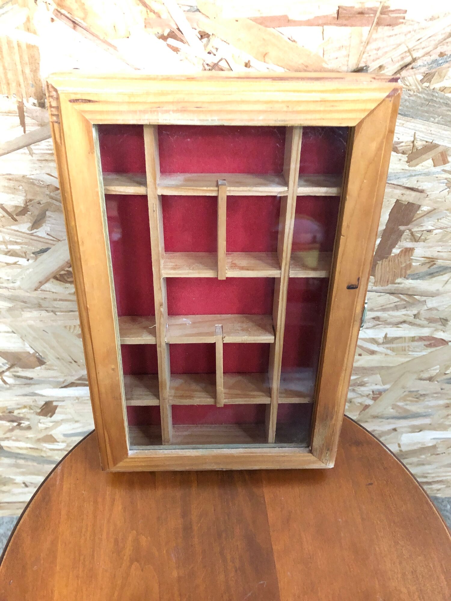 Old hanging display case with 15 wooden boxes, red background + vintage glass door