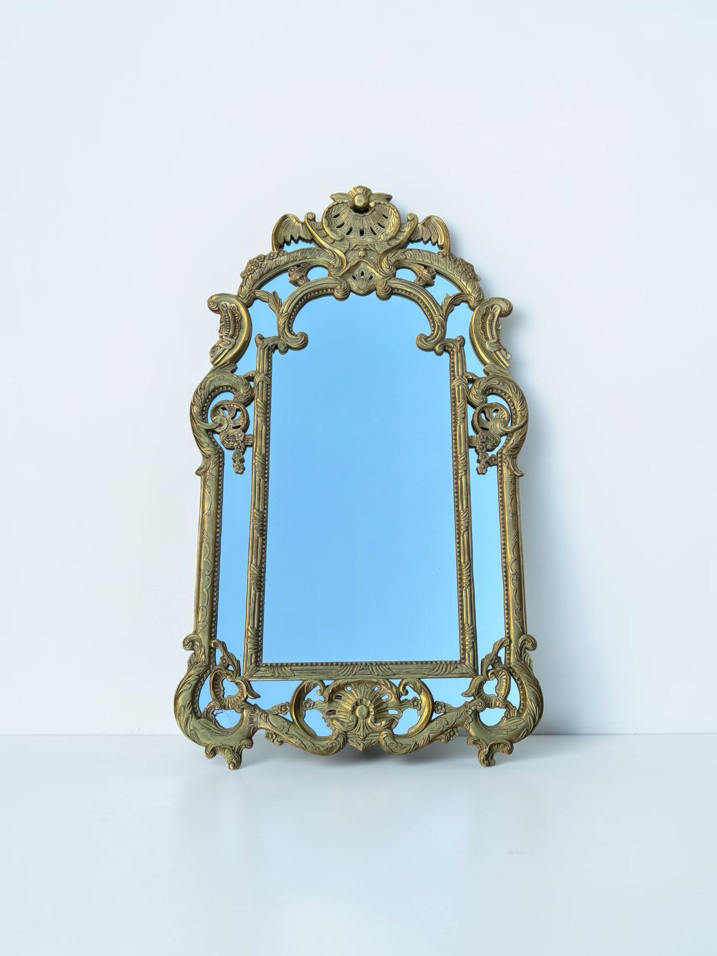 Large mirror with carved and gilded wooden frame, in Regency style.