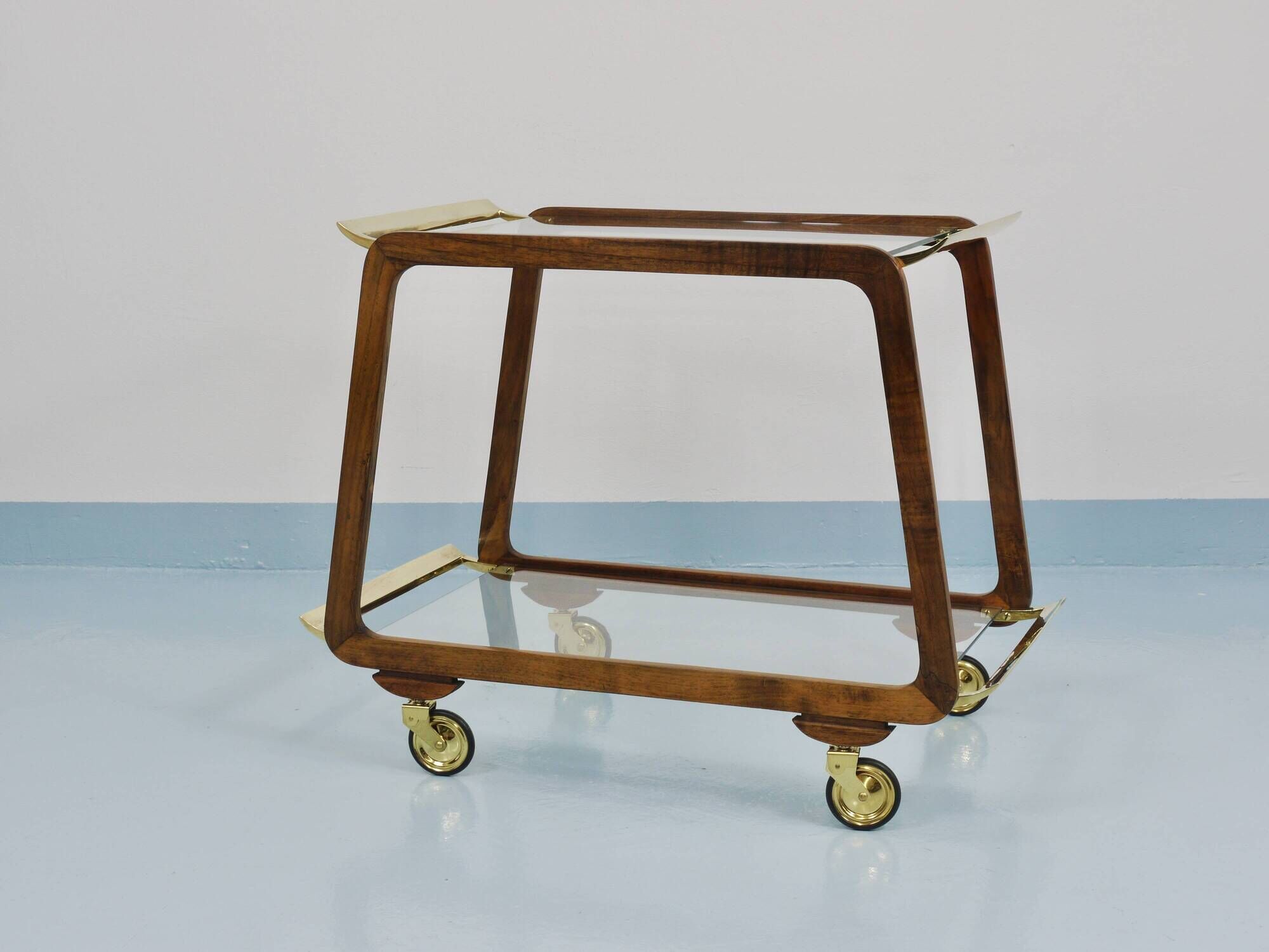 May include: A mid-century modern bar cart with a dark wood frame and two c