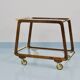 May include: A mid-century modern bar cart with a dark wood frame and two c