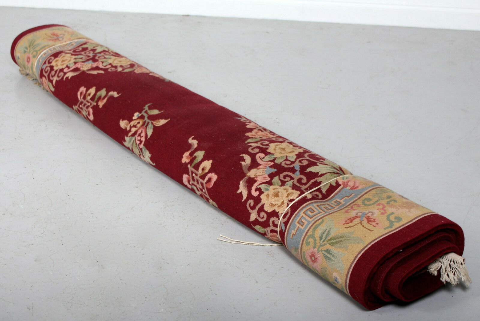 China wool fringed rug with floral pattern on deep plum background 393x274cm