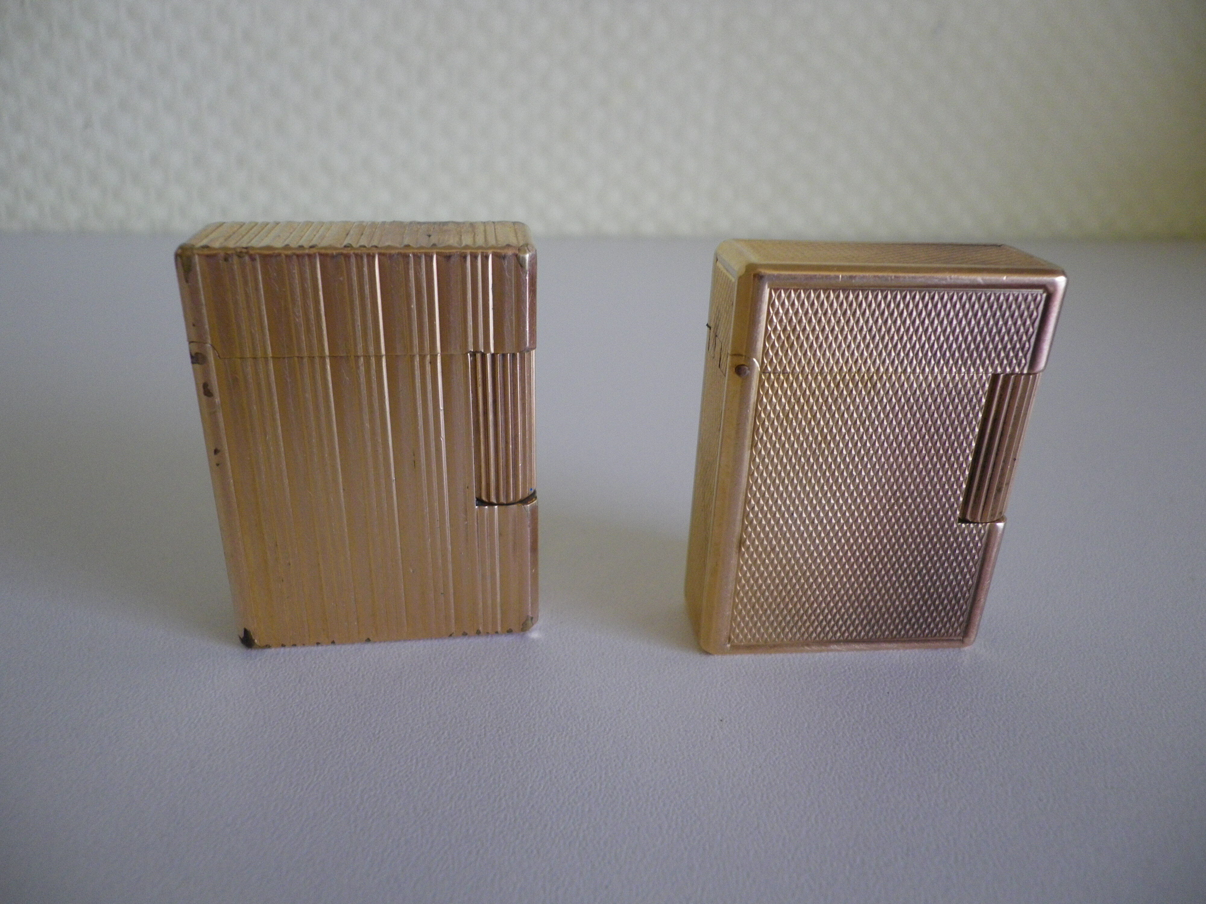 2 st dupont lighters, gold plated, punches, numbered, 1 striated pattern, 1 hammered pattern, 70s