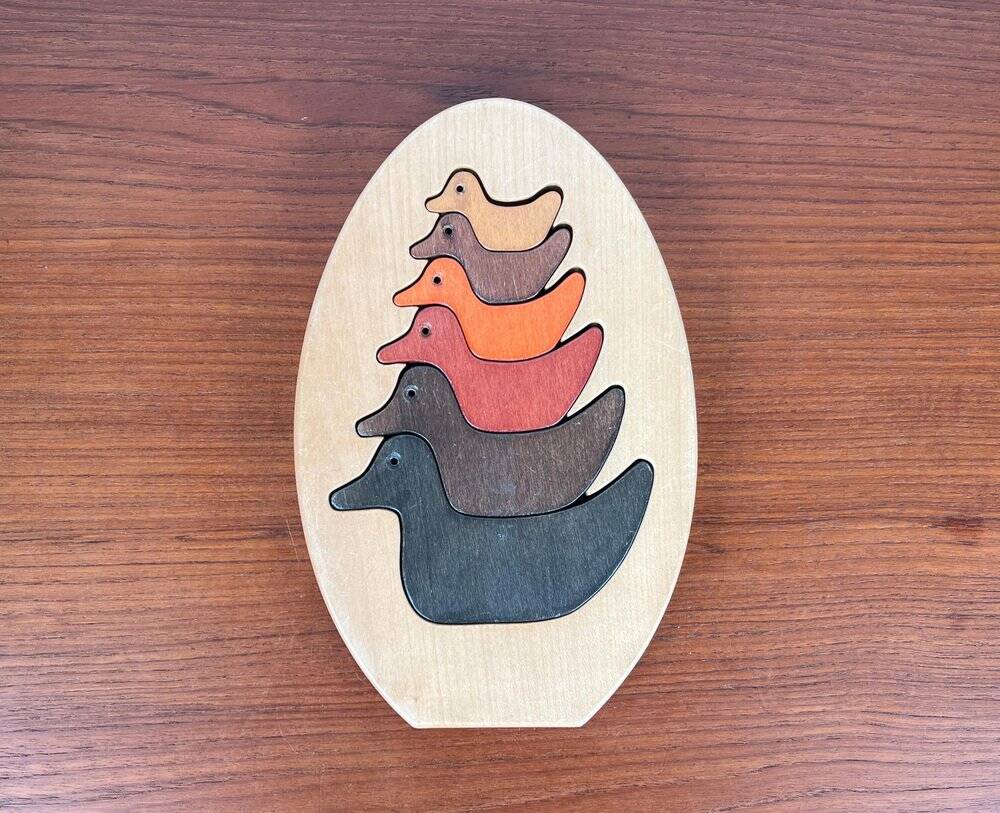 Vintage wooden puzzle with duck figurines.