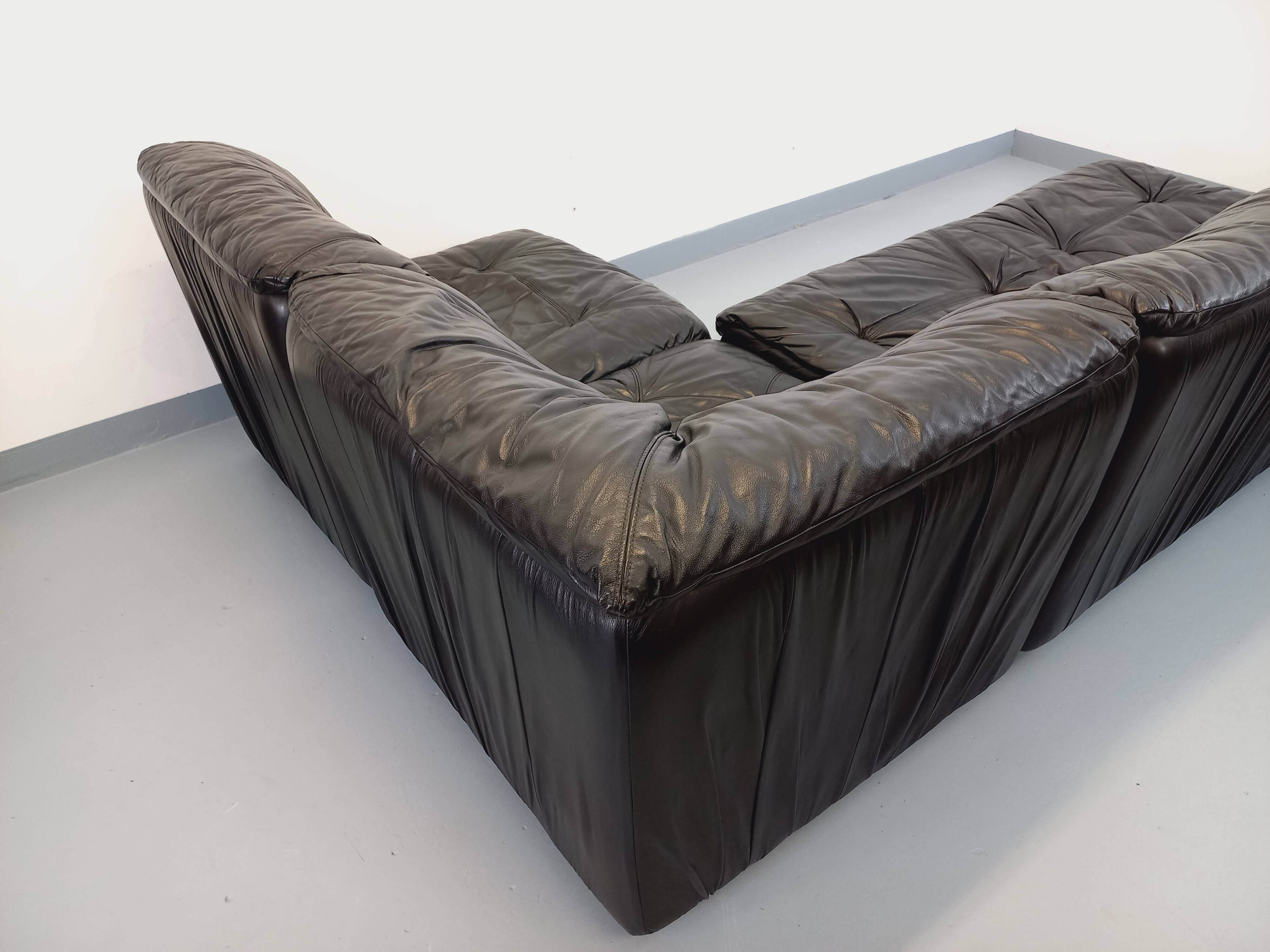 Vintage corner sofa composed of 3 modules in black leather with integrated bed.