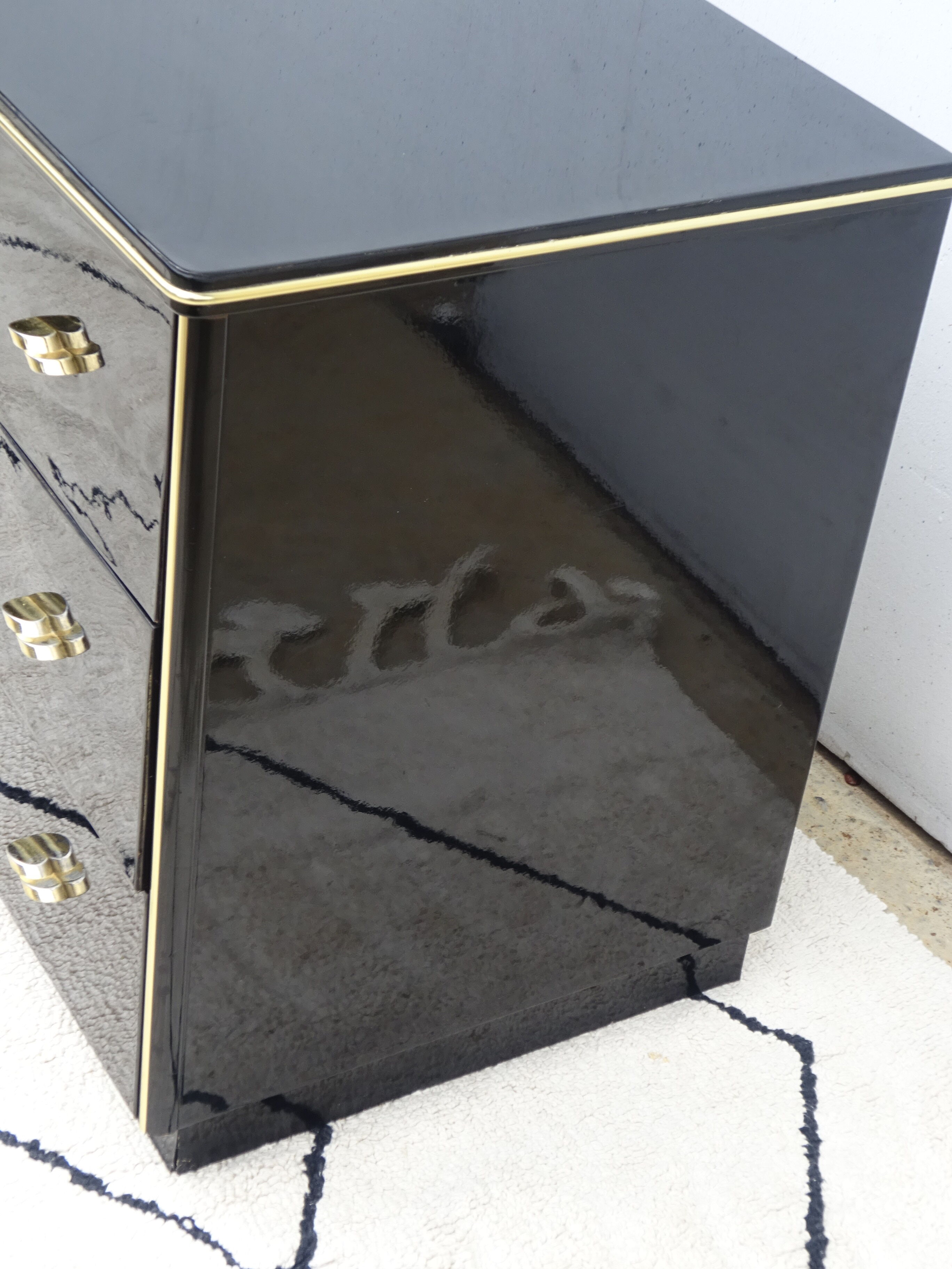 Lacquered black chest of drawers, golden brass
