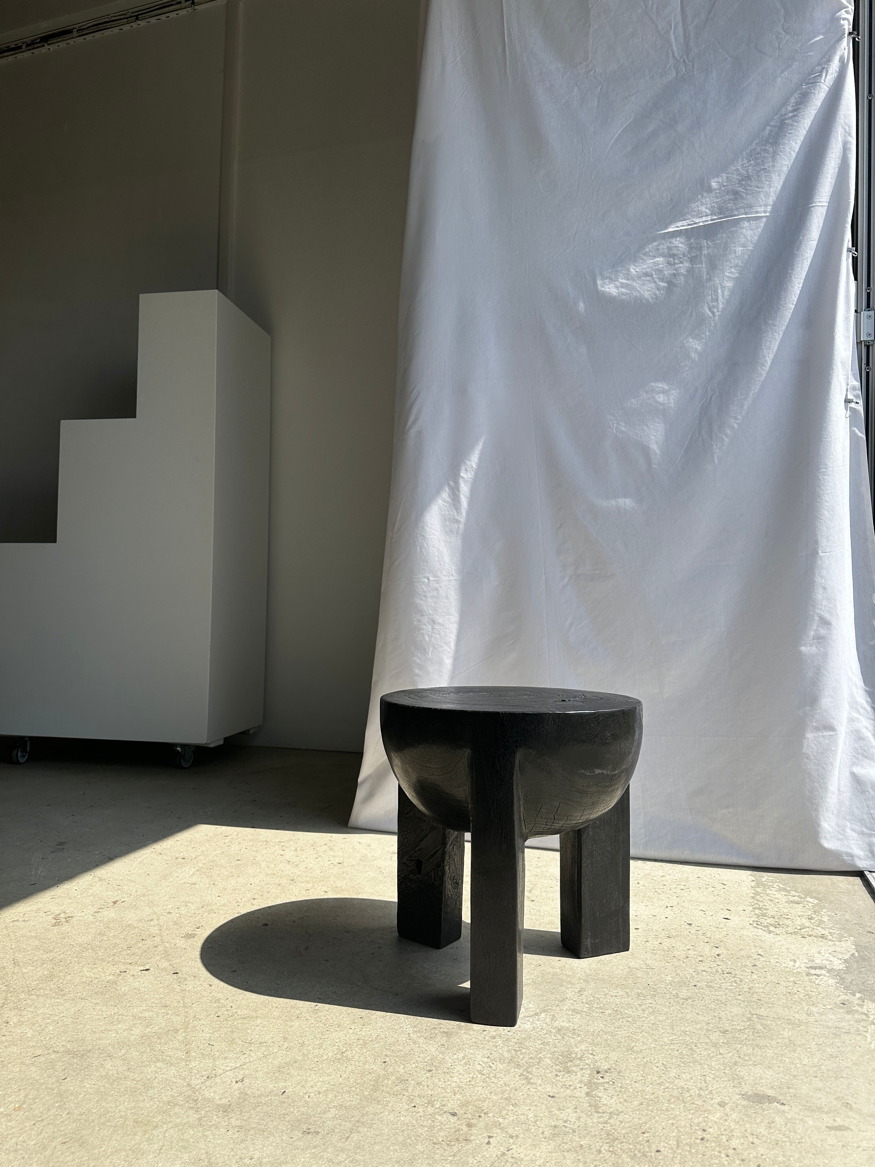 Black mango wood tripod side table with a semi-spherical top, height: 45 cm, diameter: 44 cm.