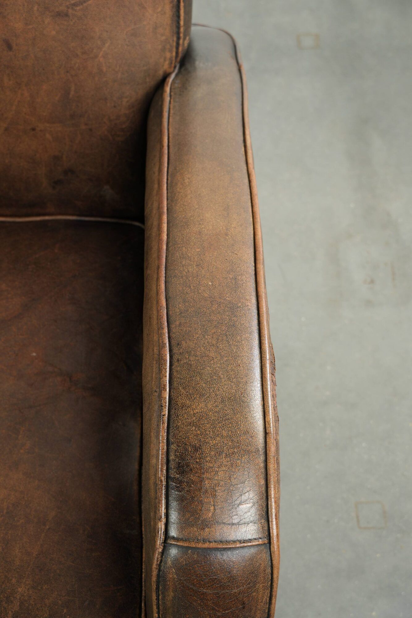 Comfortable sheepskin armchair with matching piping and a timeless look