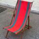 Vintage folding wooden deck chair with red and green striped canvas from the 1970s.