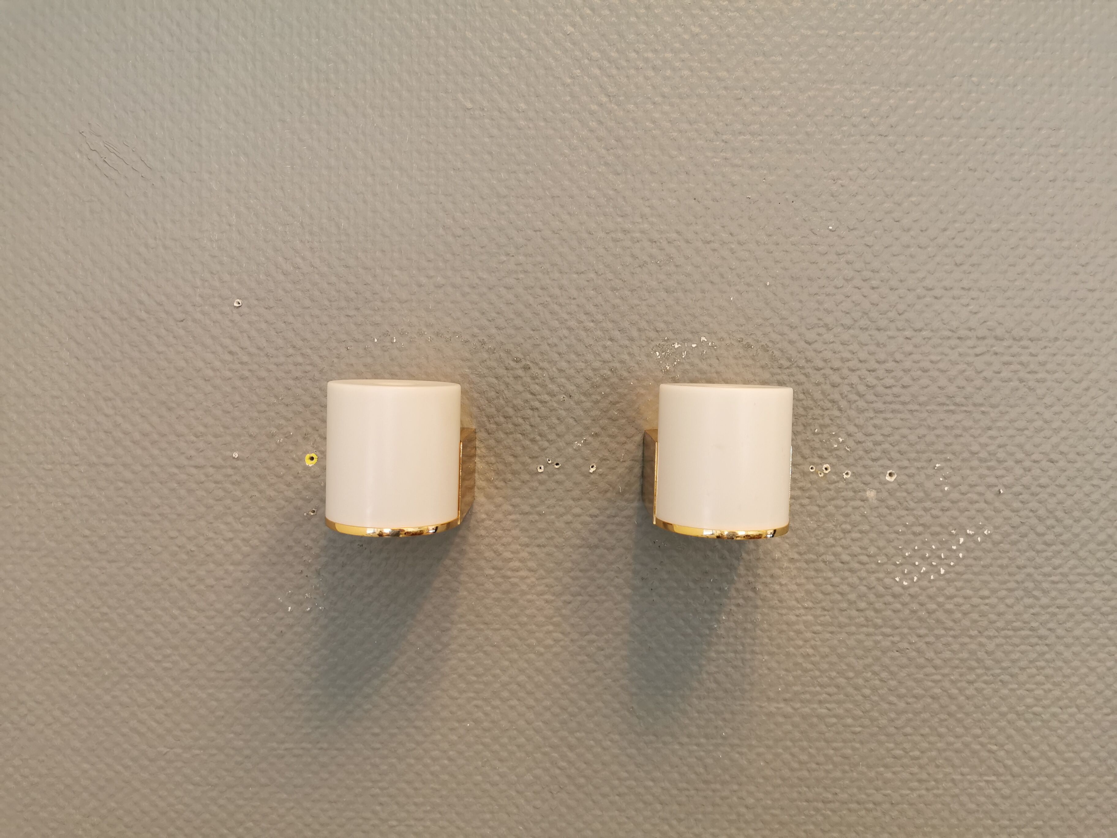 Wall lamps with milky white acrylic plastic shades and solid brass bases