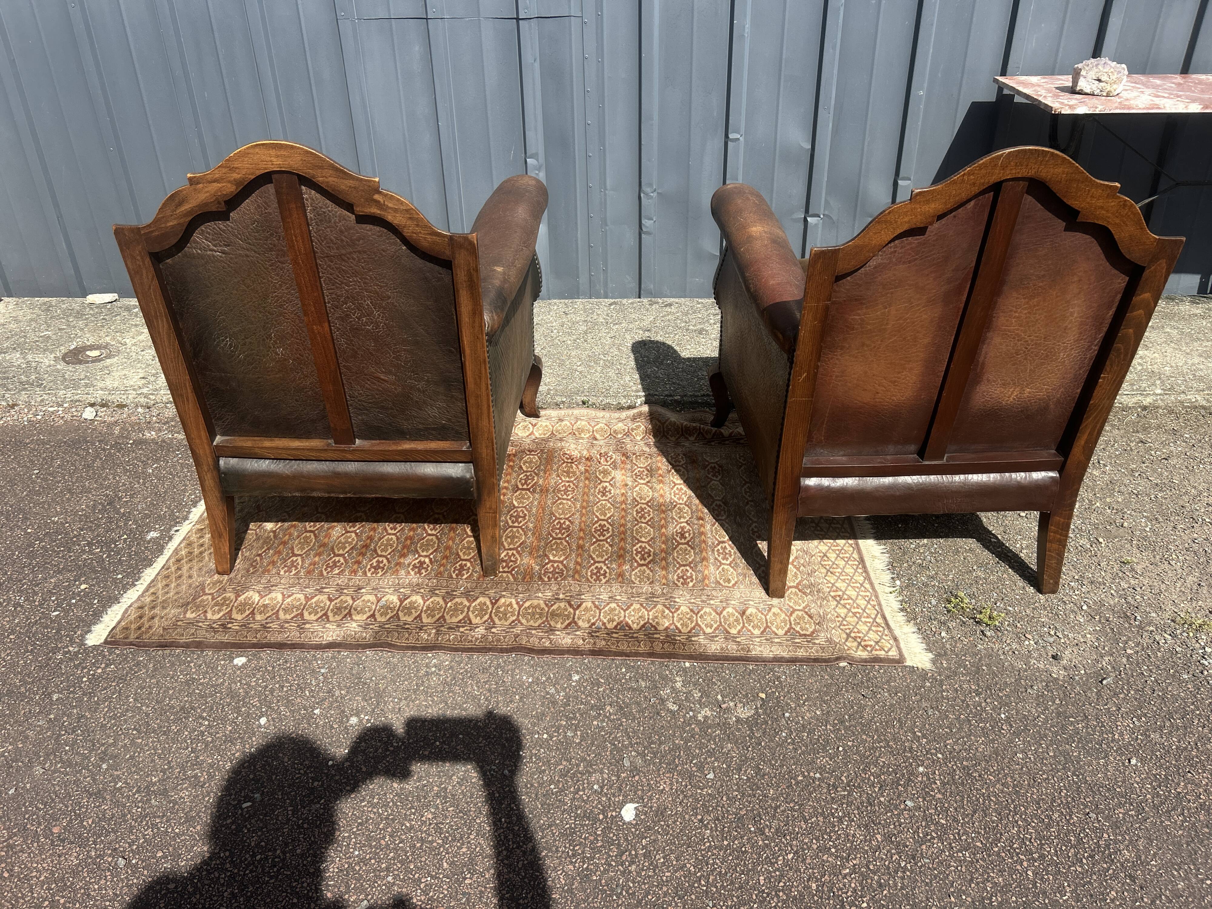 Pair of club armchairs in wood and leather, early 20th century.