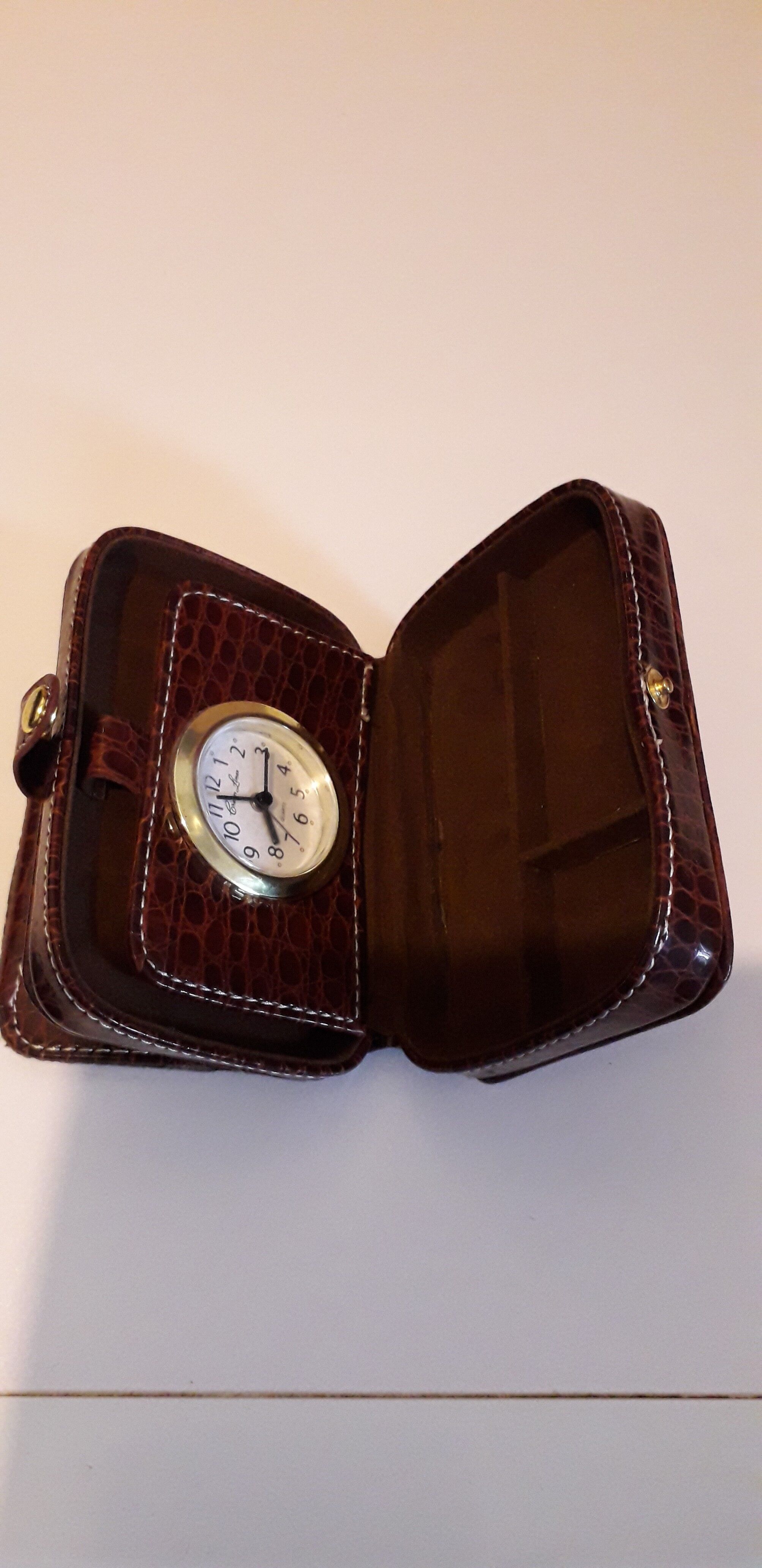Small travel alarm clock in its case with jewelry compartments