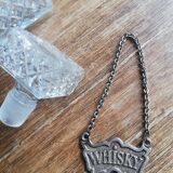 Chiseled glass whiskey decanter and its necklace marked “whiskey”