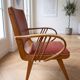 Vintage 1950s armchair in wood and red faux leather.