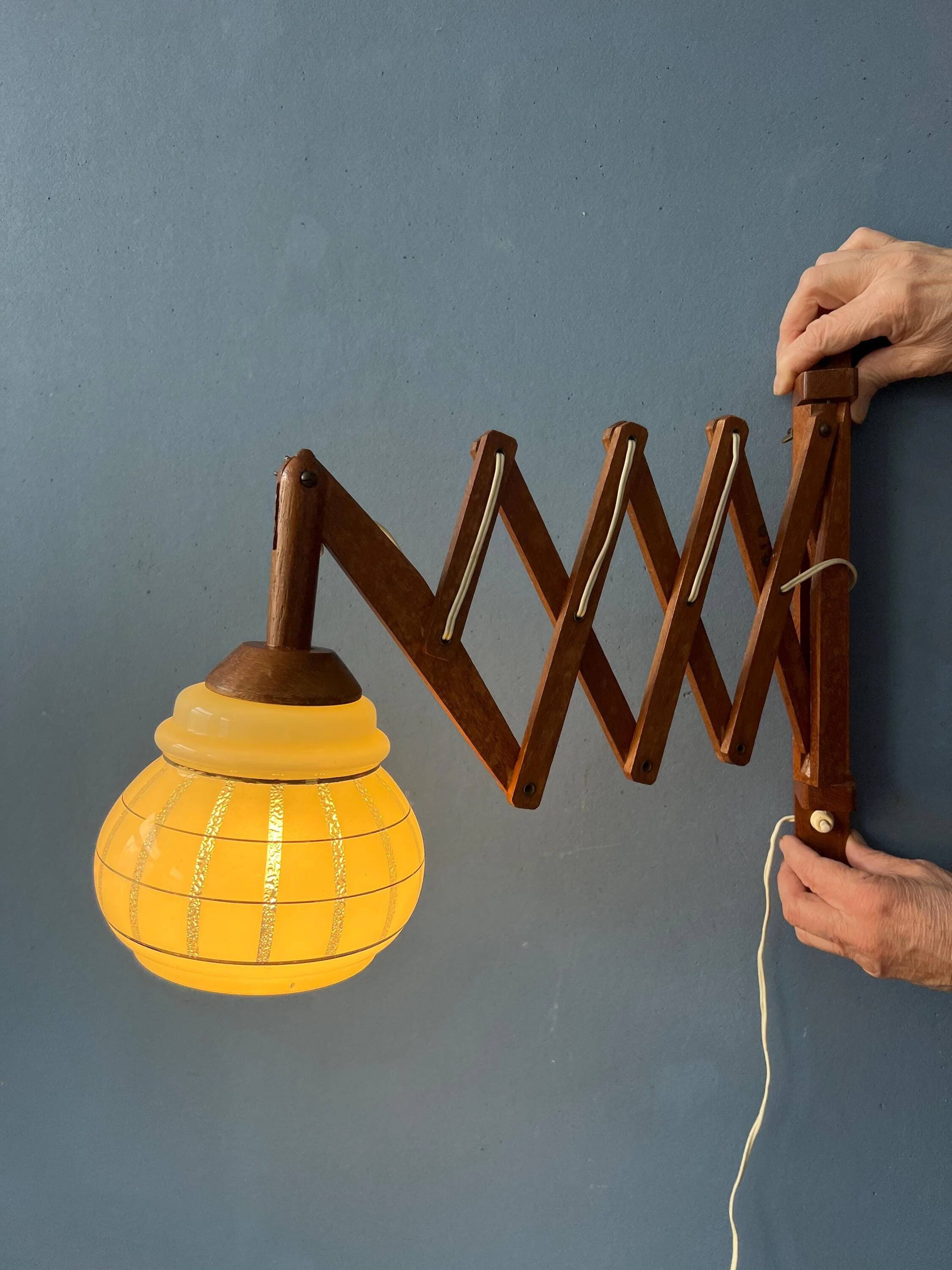 Vintage wall lamp with teak wood scissors and glass shade.