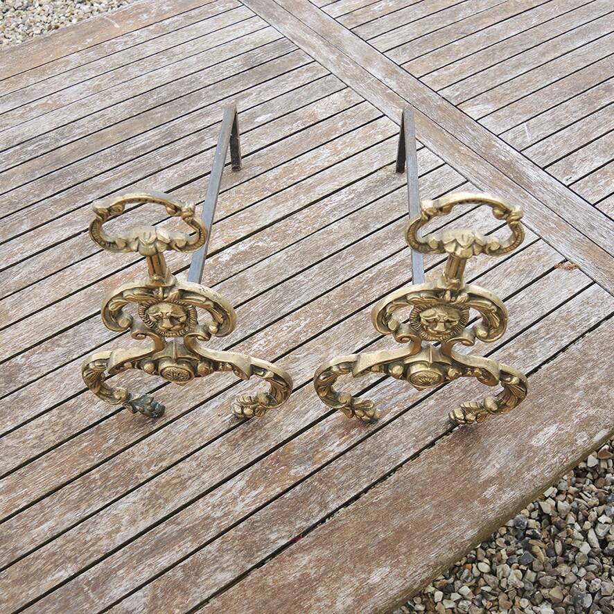 Antique brass andirons with lion decoration