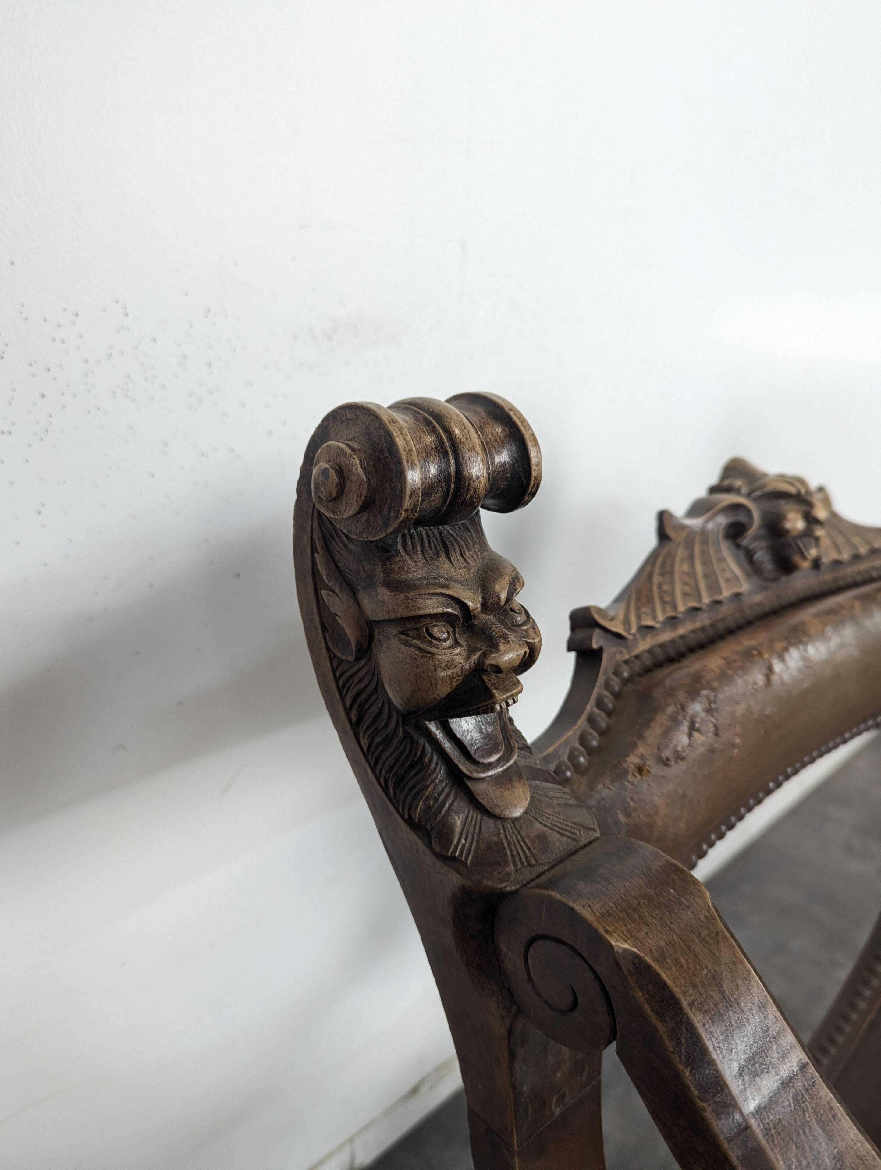 Curule chair Dagobert in carved walnut with lion heads.