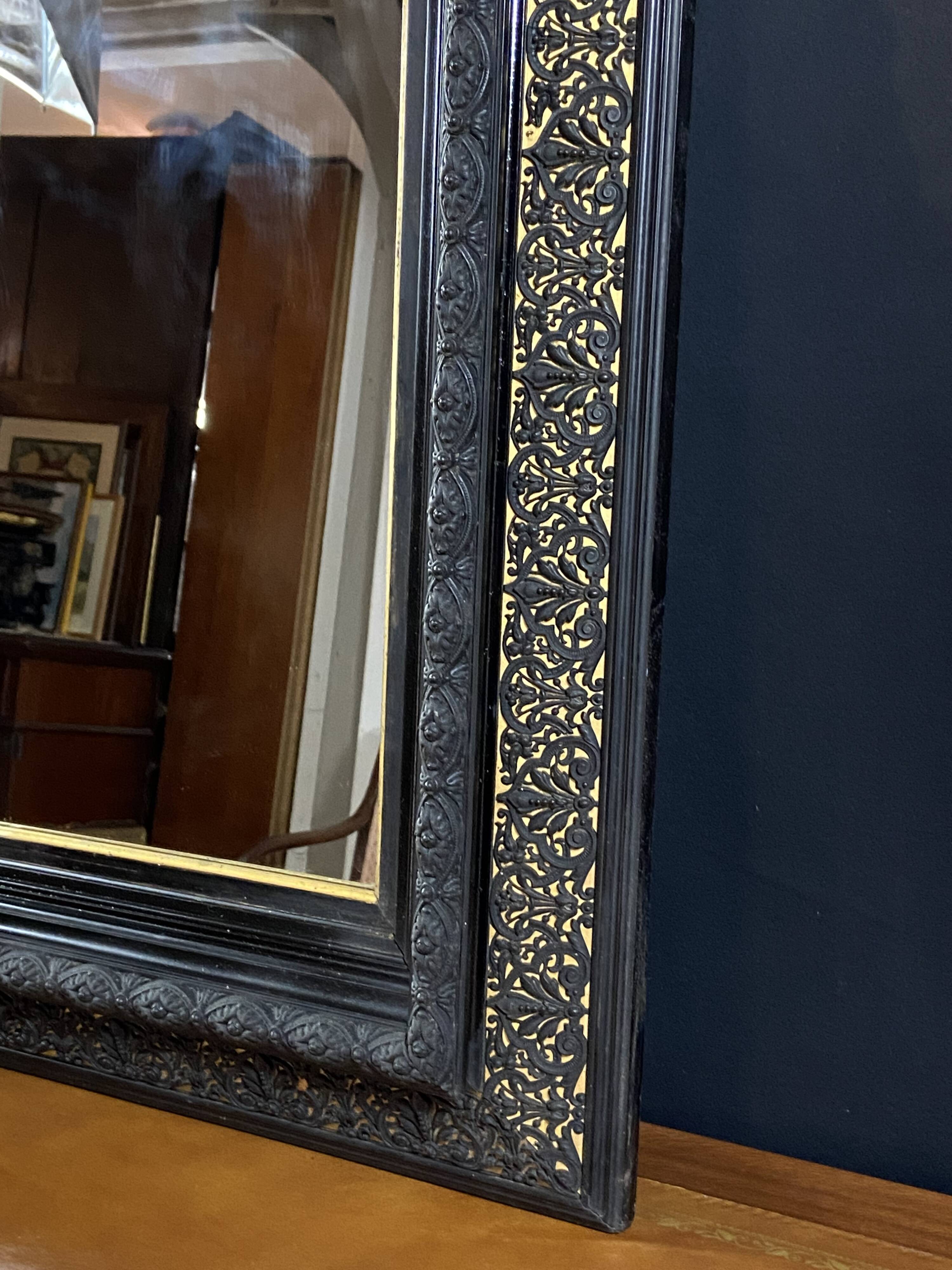 19th-century mirror Napoleon III in blackened wood on a gold background.