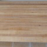 Large natural wood table with rectangular top supported by legs