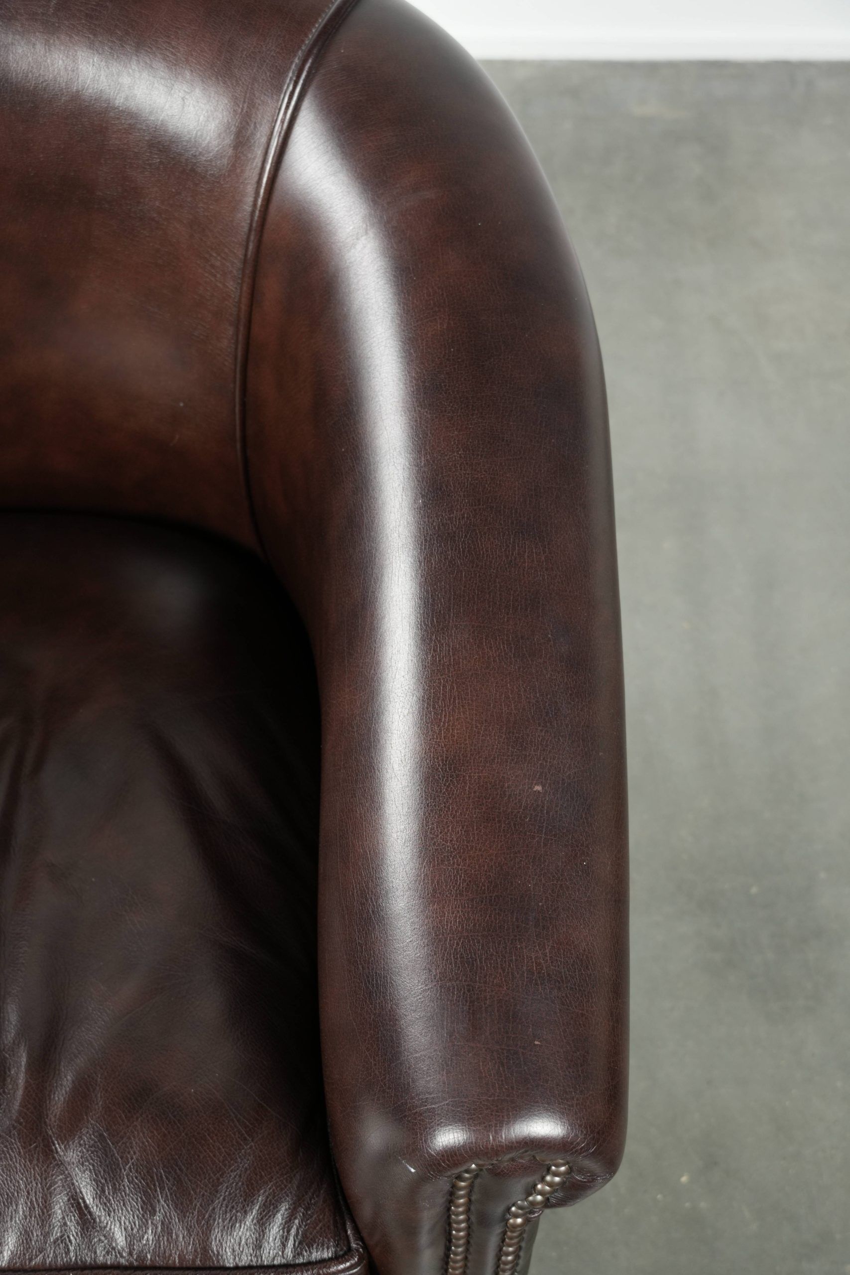 Dark cow leather club armchair with a stylish design in English style