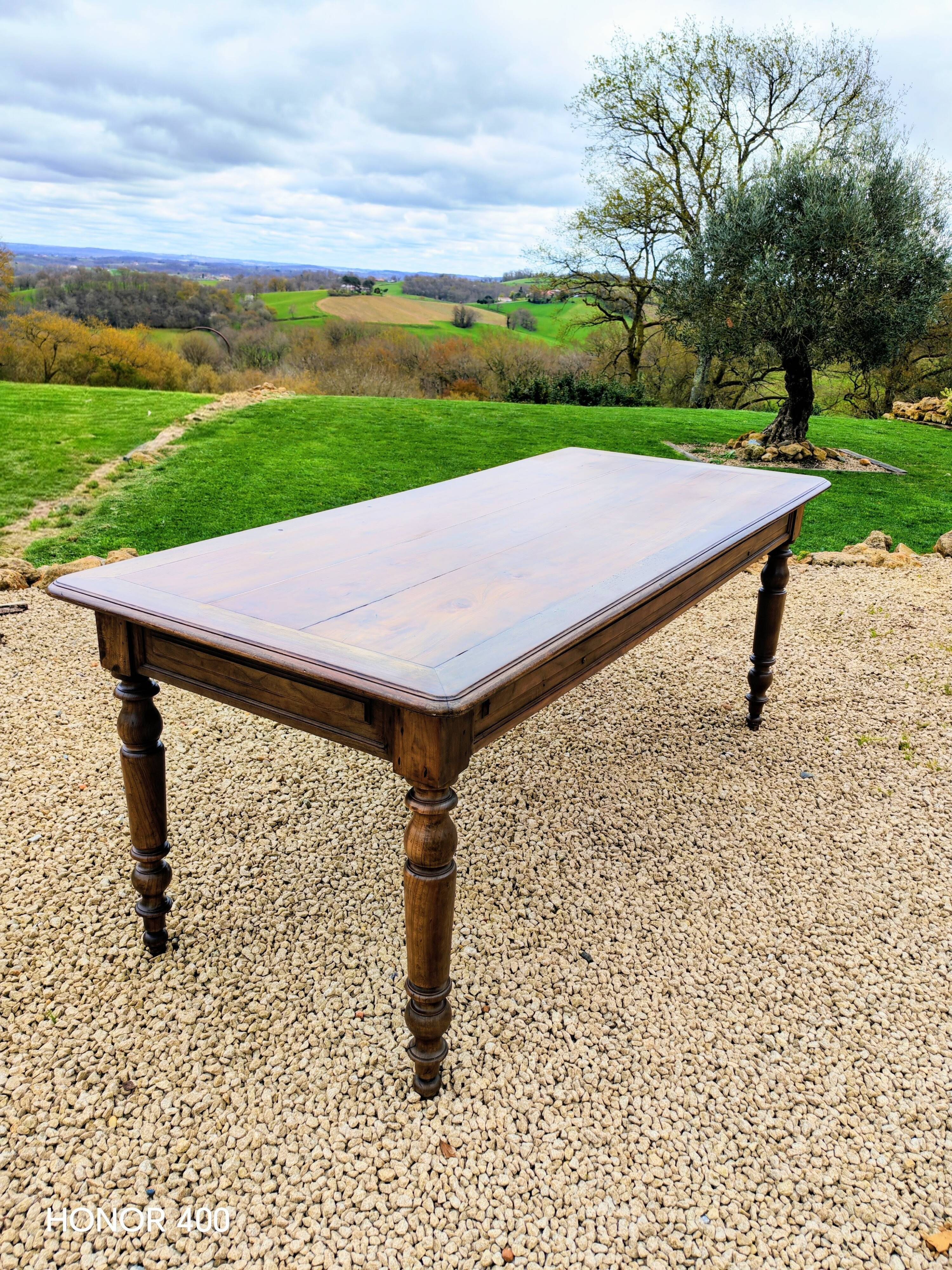 Old French farmhouse table in walnut with turned legs.