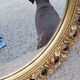 Round neoclassical style mirror in wood and gilded stucco from the 1950s