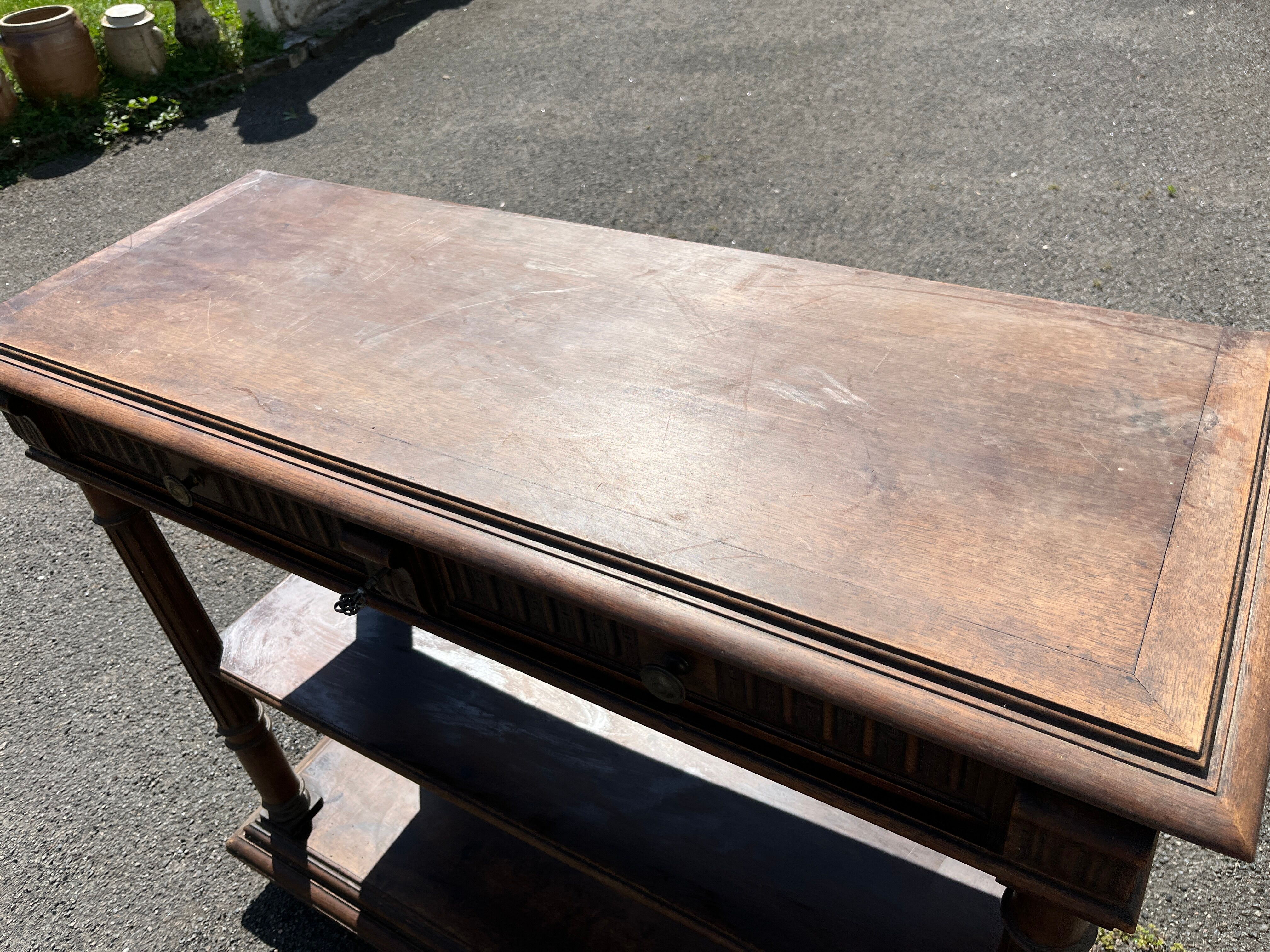 Carved wooden console table with three shelves and drop-leaf flap