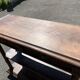 Carved wooden console table with three shelves and drop-leaf flap