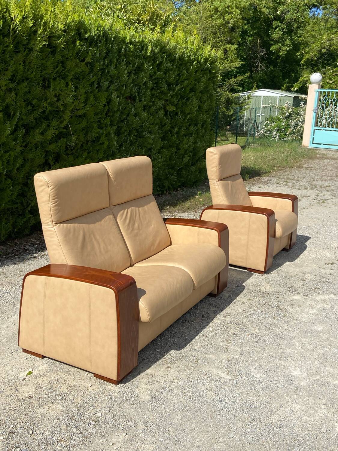 Set of vintage armchair and 2-seater sofa in beige leather and reclining wooden armrests, stressless style