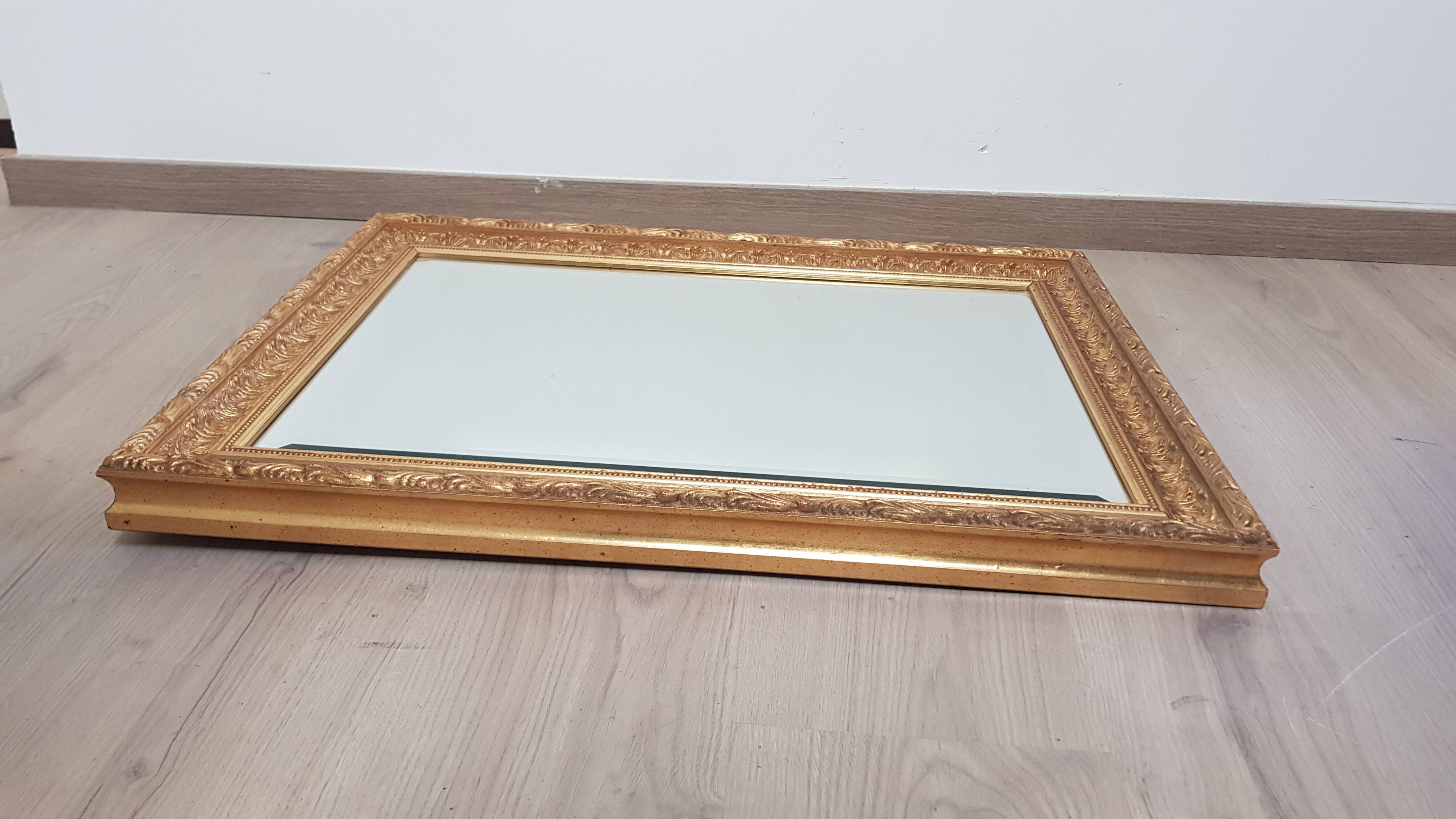Mirror in gilded stucco wood and beveled glass
