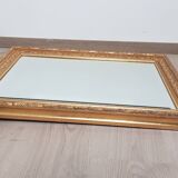 Mirror in gilded stucco wood and beveled glass