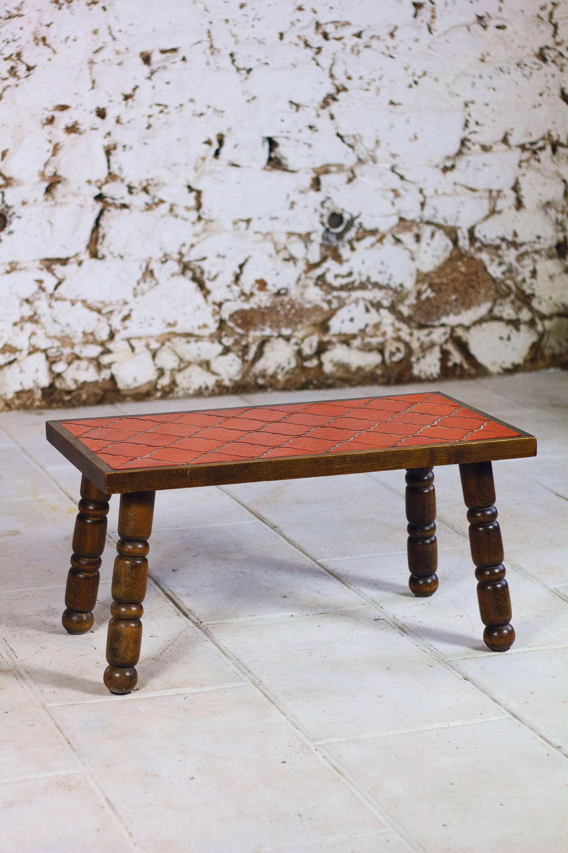 Brutalist coffee table in orange ceramic and solid wood.