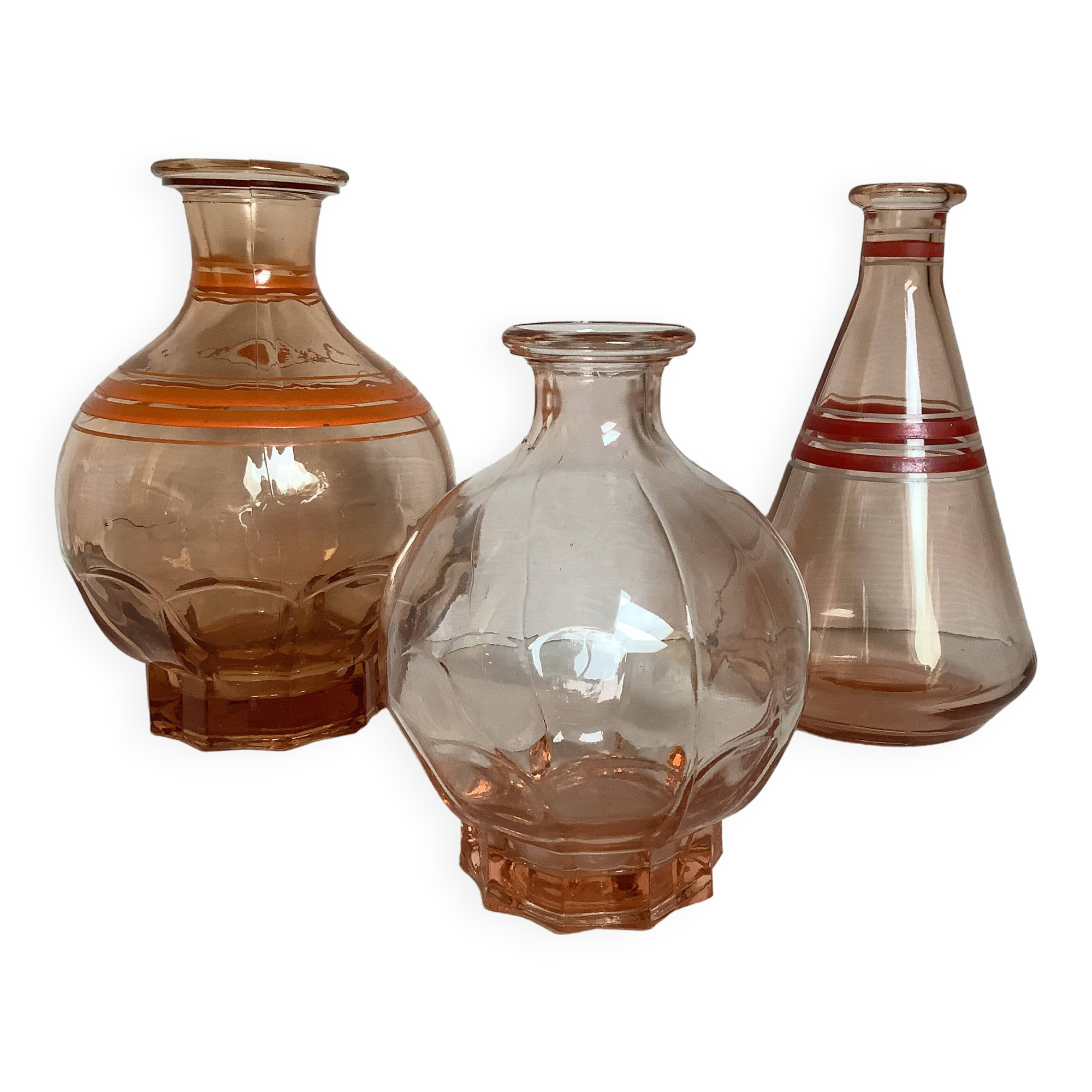 Trio of pink bottle decanters