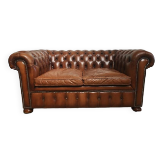 Two-seater brown leather Chesterfield sofa