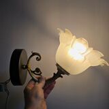 Frosted glass tulip wall sconces with brass arms.